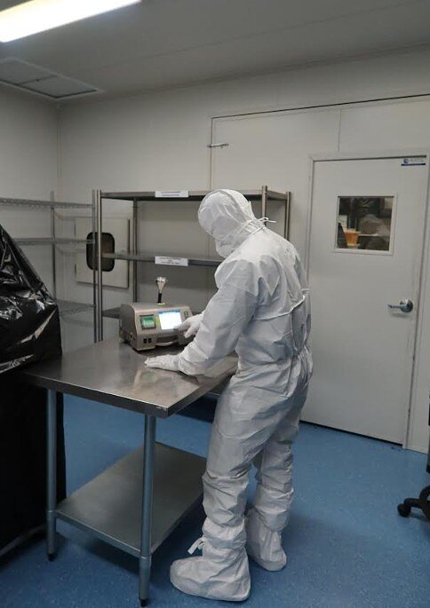 IAFS technician operating a particle counter in a cleanroom